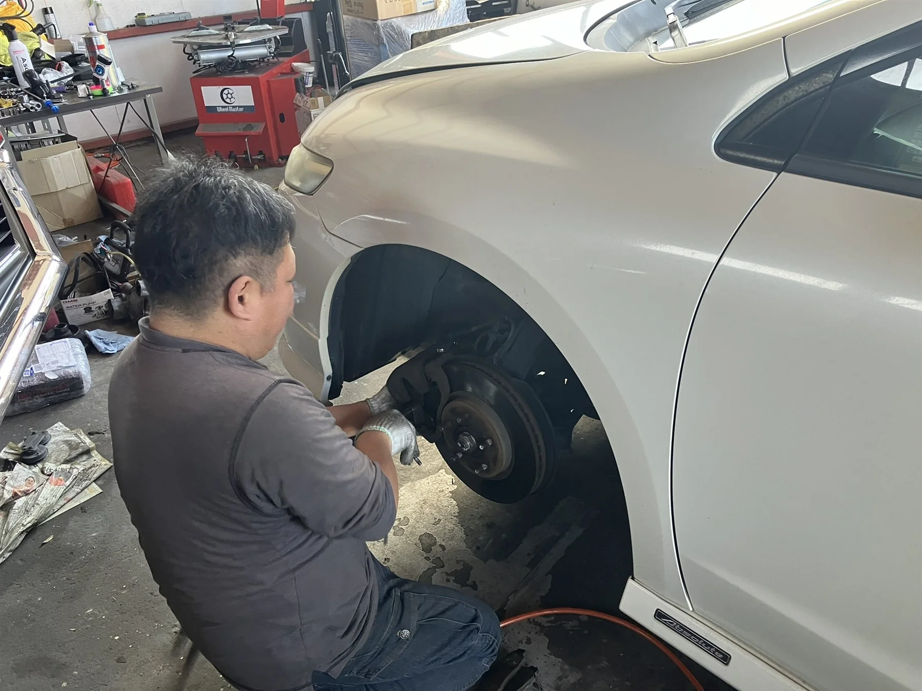 車の足回りを整備するスタッフ